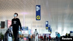 Travellers are seen at the Wuhan Tianhe International Airport after travel restrictions to leave Wuhan, the capital of Hubei province and China's epicentre of the novel coronavirus disease (COVID-19) outbreak, were lifted, April 8, 2020. REUTERS/Aly…