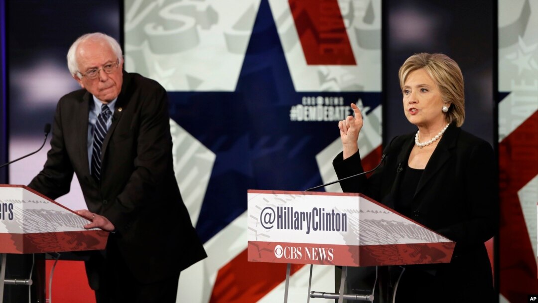 Hillary Rodham Clinton, kanan, saat debat bakal calon presiden Partai Demokrat, sementara Bernie Sanders mendengarkan di Des Moines, Iowa, 15 November 2015.