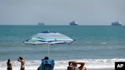Beach goers enjoy the sun, April 4, 2020, in Cape Canaveral, Fla. Some of the state’s Atlantic Ocean beaches have reopened. 