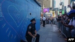 ຕຳຫຼວດນິວຢອກຄົນນຶ່ງ ຄູ້ເຂົ່່າລົງຢູ່ຕໍ່ໜ້າພວກປະທ້ວງ ຢູ່ຈະຕຸລັດ Time Square ທີ່ນະຄອນນິວຢອກ ຂອງການຕາຍ ທ້າວຈອຣຈ໌ ຟລອຍດ໌ ວັນທີ 31 ພຶດສະພາ 2020.