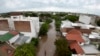 ARCHIVO - Un hombre pasea en bicicleta por una calle inundada tras una tormenta en Bahía Blanca, Argentina, el 7 de marzo de 2025. 