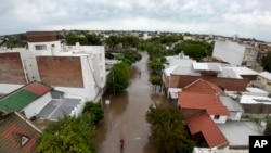 ARCHIVO - Un hombre pasea en bicicleta por una calle inundada tras una tormenta en Bahía Blanca, Argentina, el 7 de marzo de 2025. 