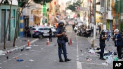 Policías patrullan una calle en un área ocupada por consumidores de la droga conocida como Crackolandia, en el centro de São Paulo, Brasil, el jueves 11 de mayo de 2023.