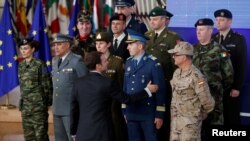 French President Emmanuel Macron greets chief of staff of European countries' armies after the launching of the Permanent Structured Cooperation, or PESCO, a pact between 25 EU governments to fund armed forces, in Brussels, Belgium, Dec. 14, 2017.