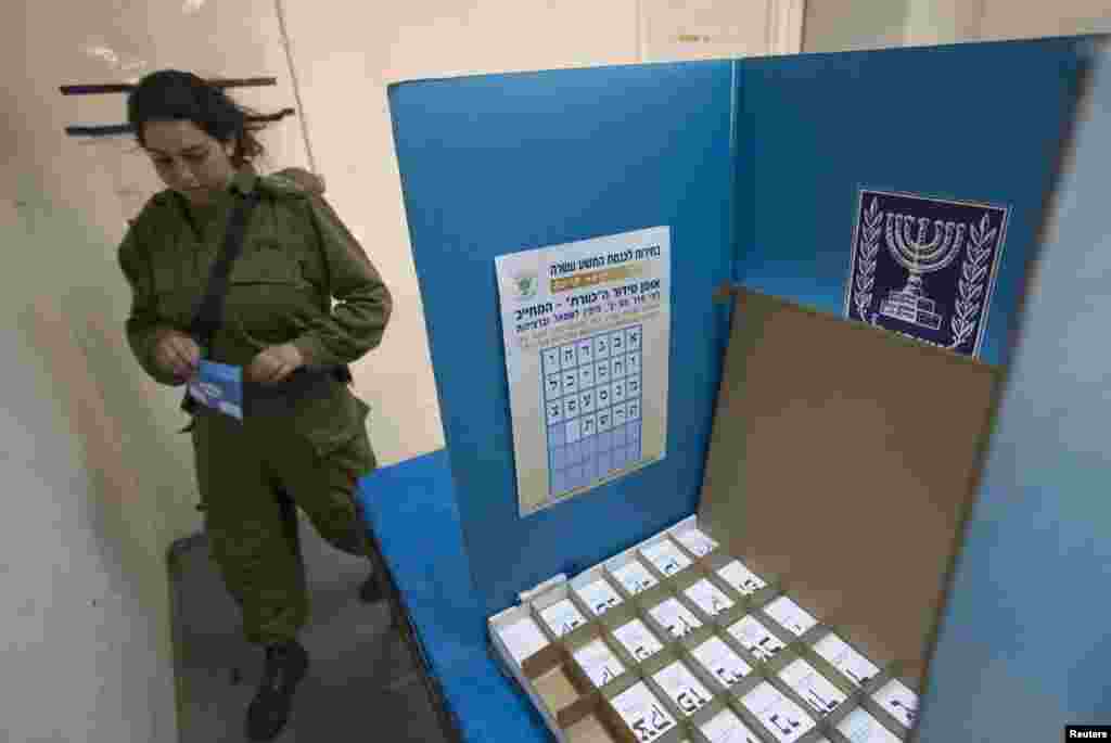 Seorang tentara Israel hendak memberikan suara di tempat pemilihan suara di sebuah basis militer di utara Israel (21/1).