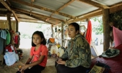 Soki Nita, sitting with her mother, Ty Linda, 27, goes to her teacher's house daily for homeschooling, in Samlout district, Battambang province, Cambodia, June 17, 2020. (Hean Socheata/VOA Khmer)