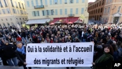 A crowd supports Cedric Herrou, a French activist farmer who faces up to five years in prison as he goes on trial accused of helping African migrants cross the border from Italy, with a banner reading "Yes to solidarity and Welcome migrants and refugees."