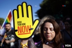 Durante el desfile del orgullo LGTBIQ+, en Jerusalén, una mujer porta un mensaje reclamando el regreso a casa de los rehenes que permanen secuestrados en Gaza, en poder de Hamas, desde el pasado 7 de octubre.