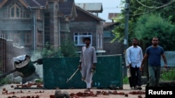 FILE PHOTO: Kashmiris walk past a blockade put up by residents to prevent security personnel from sealing off a mosque ground ahead of Eid-al-Adha prayers during restrictions following the scrapping of the special constitutional status for Kashmir by the 