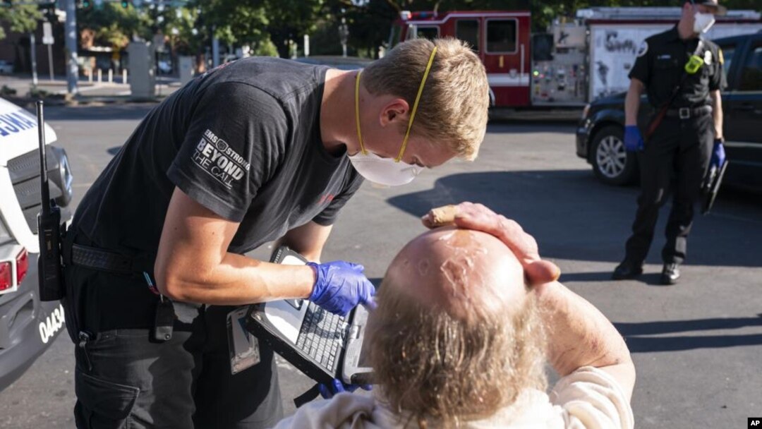 Ekipe hitne pomoći pomažu čoveku u Sejlemu, u Oregonu (Foto: AP/Nathan Howard)