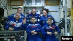 Canadian Space Agency astronaut David Saint-Jacques waves upon uniting with the rest of the crew members on the International Space Station after its capsule hatch opened upon docking in this still image captured from NASA video in space, Dec. 3, 2018. 