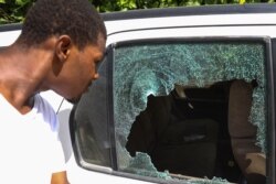 A man looks at the bullet holes in a car outside of the presidential residence in Port-au-Prince, Haiti, July 7, 2021.