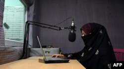 FILE - In this photo taken on Sept. 29, 2020, radio presenter Shukria Wali reads the news during a broadcast at the Merman radio station in Kandahar.