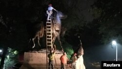 Workers remove the monuments to Robert E. Lee, commander of the pro-slavery Confederate army in the American Civil War, and Thomas "Stonewall" Jackson, a Confederate general, from Wyman Park in Baltimore, Maryland, U.S. Aug. 16, 2017. 