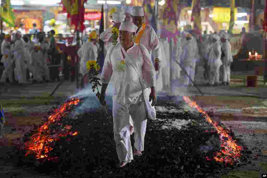 Malaysian Chinese devotees walk barefoot over burning coals during the Nine Emperor Gods festival at a temple in Kuala Lumpur, Malaysia.