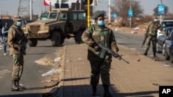 Des soldats patrouillent devant un centre commercial à Vosloorus, à l'est de Johannesburg, en Afrique du Sud, le 14 juillet 2021.