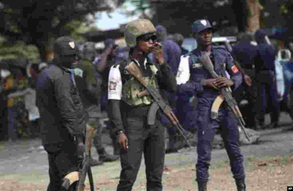 Ivory Coast policemen stand guard during a youth rally in Abidjan, Ivory Coast, 20 Dec 2010