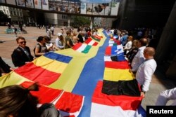 在欧洲议会大厦外，欧盟议会成员与乌克兰代表共同拉起一面长30米体现乌克兰与欧盟成员国团结一致的旗帜。（2022年6月23日）