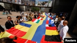 Українці в ЄС та європейці розгорнули 30-метровий прапор біля Європейського парламенту у Брюсселі, Бельгія. 23 червня 2022 року. Фото: Reuters/Yves Herman