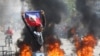 Un manifestante muestra una bandera haitiana durante una protesta para exigir la renuncia del primer ministro del país, Ariel Henry, en Puerto Príncipe, Haití, el 1 de marzo de 2024.