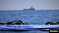 The migrant rescue ship Ocean Viking, run by two French charities, floats in the distance, as it waits in international waters between Malta and southern Italy for access to a port in this handout picture taken between Aug. 9 and 12, 2019.