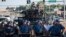 Riot police stand guard as demonstrators protest the shooting death of teenager Michael Brown in Ferguson, Missouri, Aug. 13, 2014. 