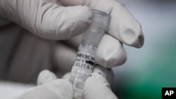 ARSIP - Pakar biologi, Rebecca Gillespie, mengangkat tabung berisi antibodi untuk menanggulangi flu di Pusat Penelitian Vaksin di National Institutes of Health, Bethesda, Maryland, 19 Desember 2017 (foto: AP Photo/Carolyn Kaster)