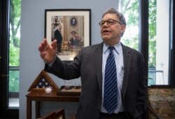 ARCHIVO - El senador Al Franken, demócrata por Minnesota, recuerda su comienzo en la política parado frente a una foto con su compañero de Minnesota Walter Mondale, quien fue senador y vicepresidente. Miércoles de junio. 15, 2016.