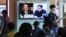 2018年4月18日，在韩国首尔火车站，人们观看电视新闻节目，屏幕上显示蓬佩奥和朝鲜领导人金正恩各自的肖像。