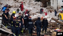 Tim penyelamat mencari korban selamat di rumah-rumah yang terendam banjir di dekat ngarai Sungai Neretva, menyusul hujan lebat di Desa Donja Jablanica, sekitar 50 kilometer barat daya Sarajevo pada 5 Oktober 2024. (Foto: AFP)