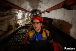 Krystyna, 22-years-old, stands next to a mine train battery at her workplace at an underground mine, amid Russia's attack on Ukraine, in Dnipropetrovsk region, Ukraine on November 17, 2023. (REUTERS/Alina Smutko)