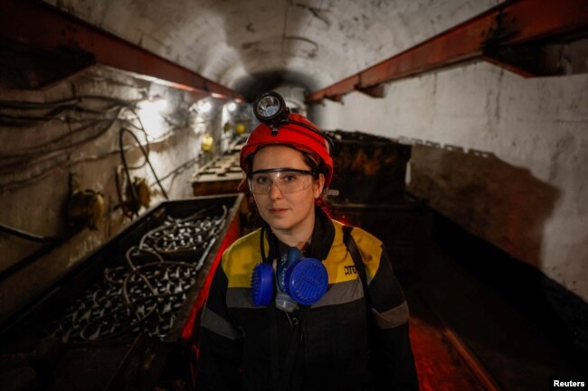 Krystyna, 22-years-old, stands next to a mine train battery at her workplace at an underground mine, amid Russia's attack on Ukraine, in Dnipropetrovsk region, Ukraine on November 17, 2023. (REUTERS/Alina Smutko)