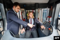 FILE - Christopher Hecht instructs Benedikt Hanne, a social work student at a university, in driving streetcars in Nuremberg, southern Germany, on March 21, 2024. . Nuremberg, Germany's city services is looking to expand its worker pool. (Daniel Karmann / AFP)