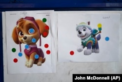 Siswa TK menempelkan stiker berwarna pada karakter acara TV PAW Patrol untuk memilih mana yang paling populer di ACCA Child Development Center, 19 September 2024, Annandale, AS. (John McDonnell/AP)