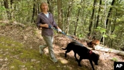 FILE - Susannah Johnston, of Croton-on-Hudson, N.Y., walks her dog Ellie on Sept. 8, 2024 in Norfolk, Conn. Johnston, a fit yoga instructor and strength trainer, has been injured three times in incidents involving walking her dog. (Vincent Cohan via AP)