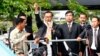 Sam Rainsy, leader of the opposition Cambodia National Rescue Party (CNRP), delivers a speech from a vehicle upon his arrival at Phnom Penh International Airport in Phnom Penh, July 19, 2014. 