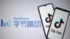 FILE - Tik Tok logos are seen on smartphones in front of a displayed ByteDance logo, Nov. 27, 2019. 