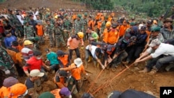 Tim SAR mencoba menarik mayat korban tanah longsor di Jemblung, Jawa Tengah, Indonesia, 14 Desember 2014.