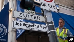 Un trabajador instala el letrero de la calle Joe Rosenthal Way para honrar a quien ganó el Premio Pulitzer por su icónica foto de los marines estadounidenses izando la bandera en la isla japonesa de Iwo Jima, el 12 de diciembre de 2024, en San Francisco.