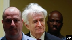 Former Bosnian Serb leader Radovan Karadzic, center, arrives to open his appeal at a U.N. court against his convictions on charges including genocide and crimes against humanity and his 40-year prison sentence in The Hague, Netherlands, April 23, 2018.