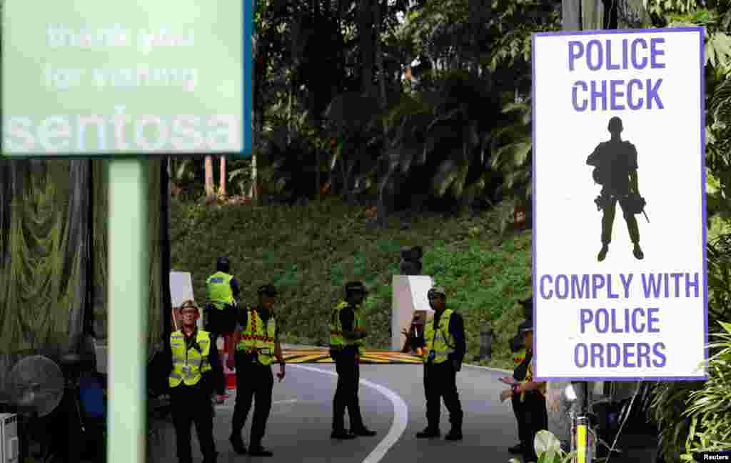 Petugas kepolisian dan bantuan polisi (banpol( berjaga di depan pintu masuk Hotel Cappela di Pulau Sentosa, Singapura, 11 Juni 2018. (Reuters/Kim Kyung-Hoon)