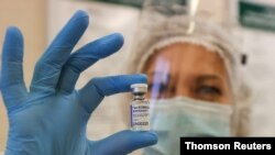 Un trabajador médico muestra un frasco con la vacuna Sputnik V durante la vacunación contra la enfermedad por coronavirus en una clínica de Minsk, Bielorrusia. [Archivo de Reuters].