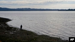 FILE - A fisherman walks on the shore of the fishing village Quetalmahue in Chile's Chiloe island, May 10, 2016. Scrub typhus has been confirmed in a cluster of cases on the island, far from places it usually strikes.