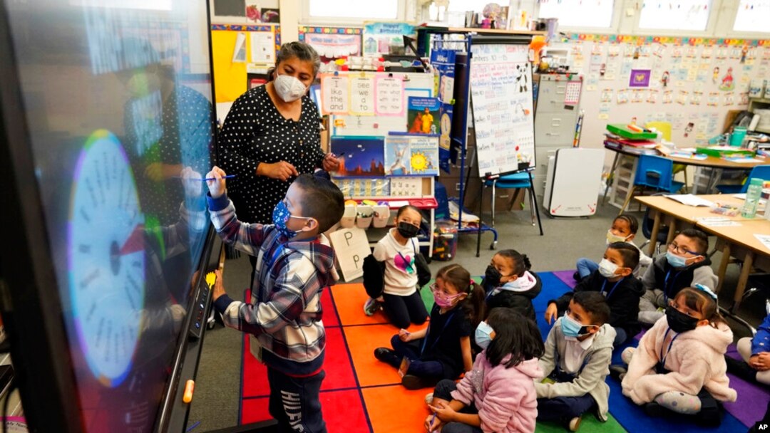 Kindergarten teacher Ana Zavala, at left, instructs students amid the COVID-19 pandemic at Washington Elementary School, Jan. 12, 2022, in Lynwood, Calif.