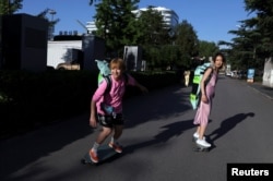 Mina Zhao,40, and Zheng Yue, 27, who are both members of Beijing Girls Surfskating Community, ride their skateboards on the streets of Beijing, China July 6, 2022. (REUTERS/Tingshu Wang)