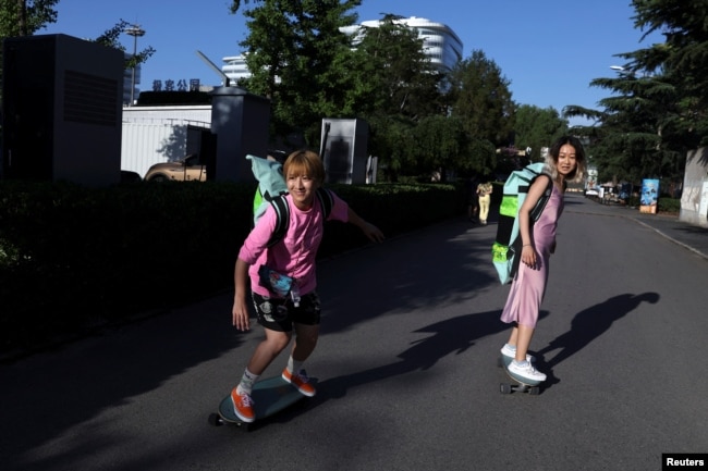 Mina Zhao,40, and Zheng Yue, 27, who are both members of Beijing Girls Surfskating Community, ride their skateboards on the streets of Beijing, China July 6, 2022. (REUTERS/Tingshu Wang)