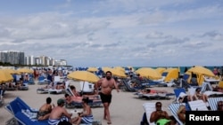FILE - Revelers flock to the beach to celebrate spring break, amid the coronavirus outbreak in Miami Beach, Florida, March 6, 2021. 