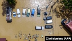 Foto yang diambil dari udara ini memperlihatkan kendaraan yang terendam banjir saat banjir di Lhoksukon, Aceh Utara pada 4 Januari 2022. (Foto: AFP/Zikri Maulana)