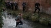 A man runs with the ball in the Henmore Brook during the annual Shrovetide medieval football match played in Ashbourne, England, March 4, 2025. 