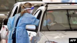 A member of the medical personnel takes a swab at a drive-through Covid-19 testing station in Melbourne, Aug. 19, 2021, as Australia battles an outbreak of the Delta variant of coronavirus. 